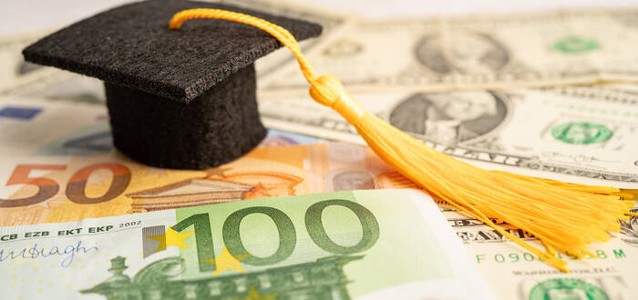 graduation-gap-hat-on-us-dollar-banknotes-money-e-2025-02-25-09-36-33-utc